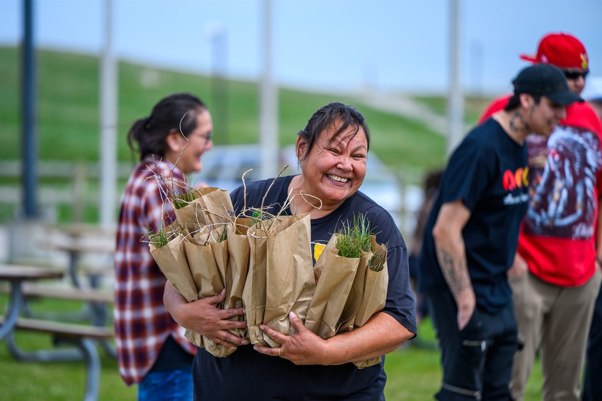 A smiling volunteer holding bags of seedlings