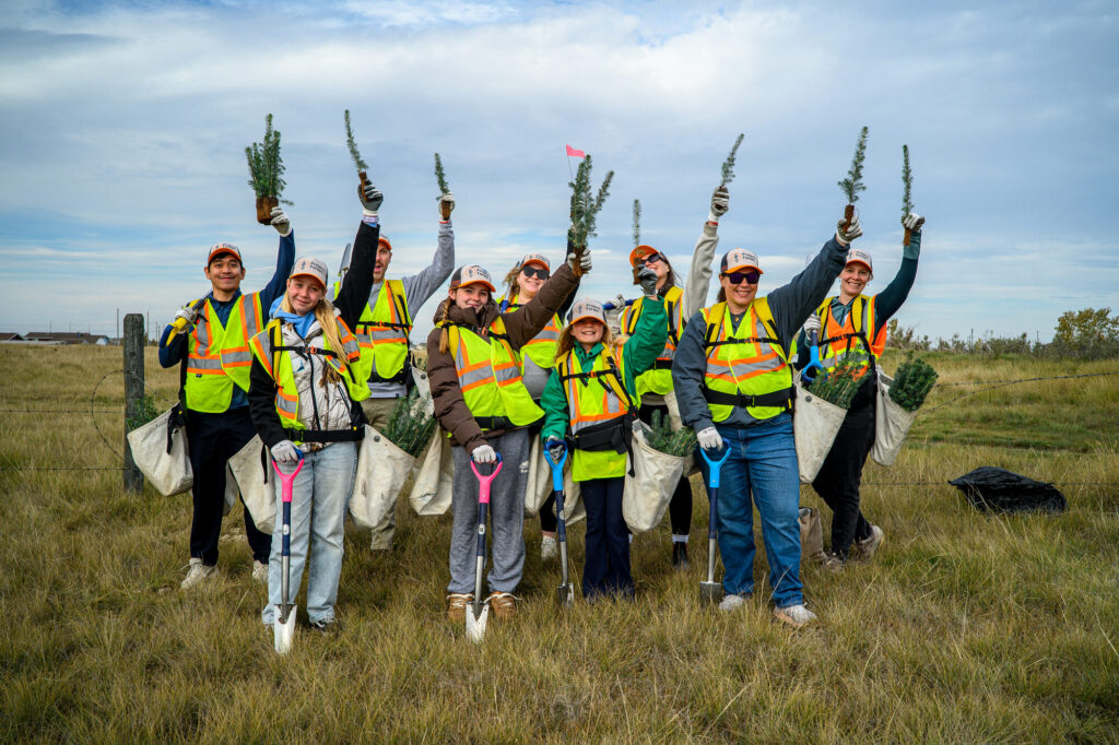 A team of planters raising seedlings in celebration