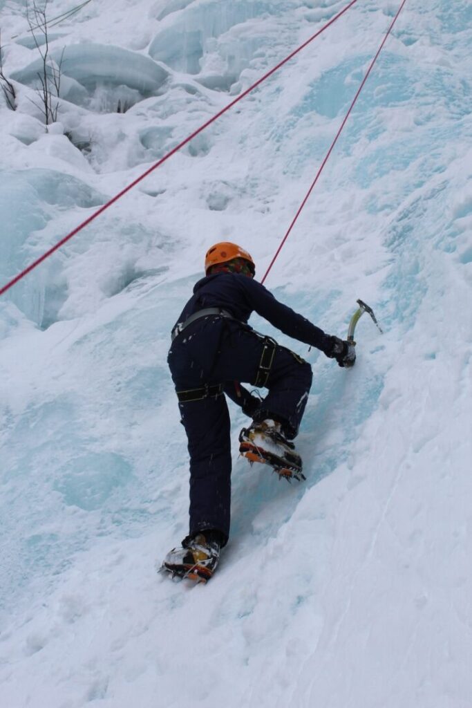 A Junior Forest Warden ice climbing up a frozen wall