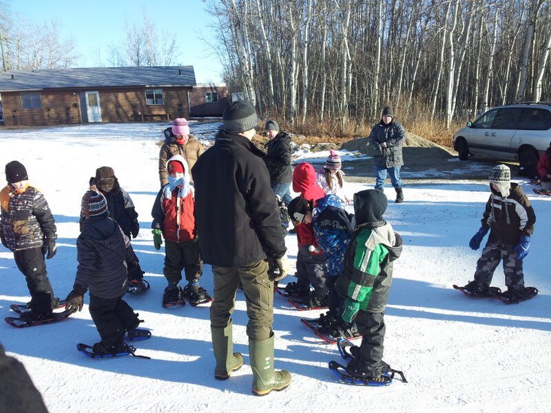 A group of children and leaders in snowshoes
